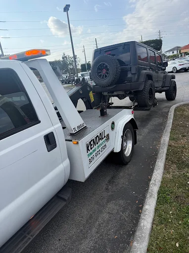 Kendall Towing Services flatbed truck towing a Jeep in Miami